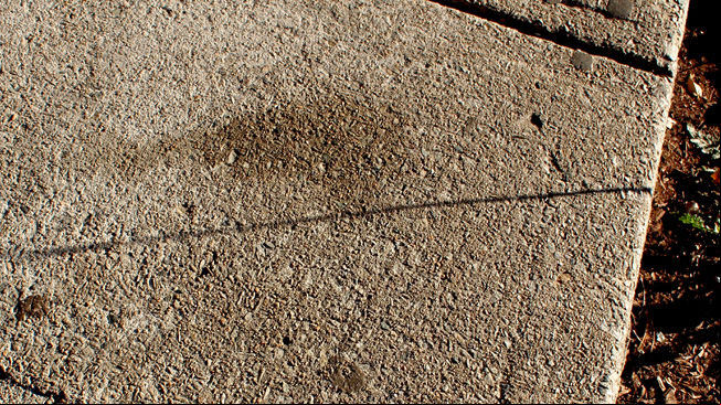 Disappearing letter A drawn in water on pavement