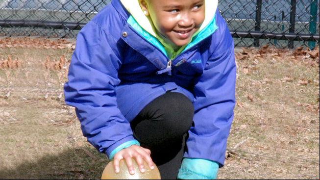 Girl kneeling by ball