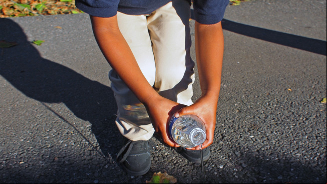Kid pours water from a bottle