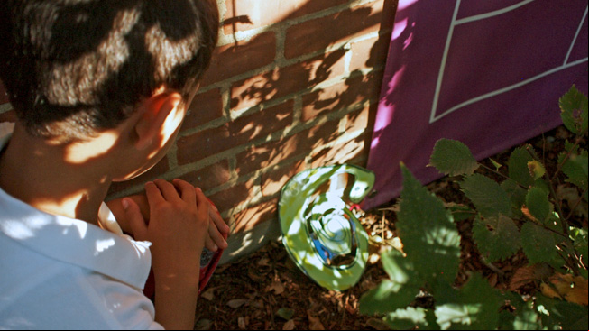 Boy hiding snake art in shadows