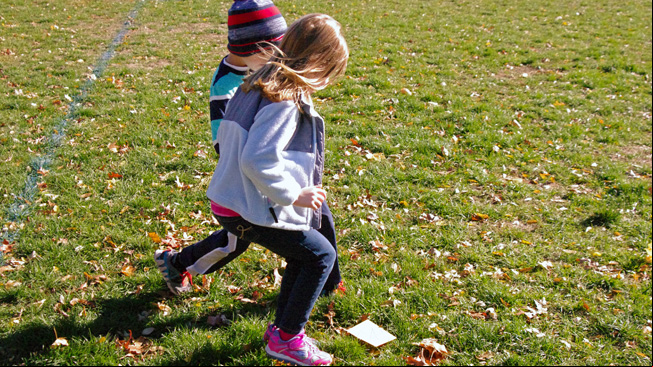 Kids run to paper shape on ground
