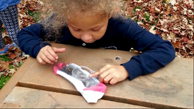 Girl examines sock at table