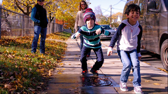Two boys jump puddle